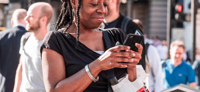 lächelnde Frau mit Mobiltelefon in der Hand