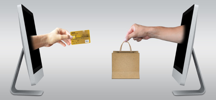 Hand mit Kreditkarte kommt aus Monitor und greift  Einkaufstüte